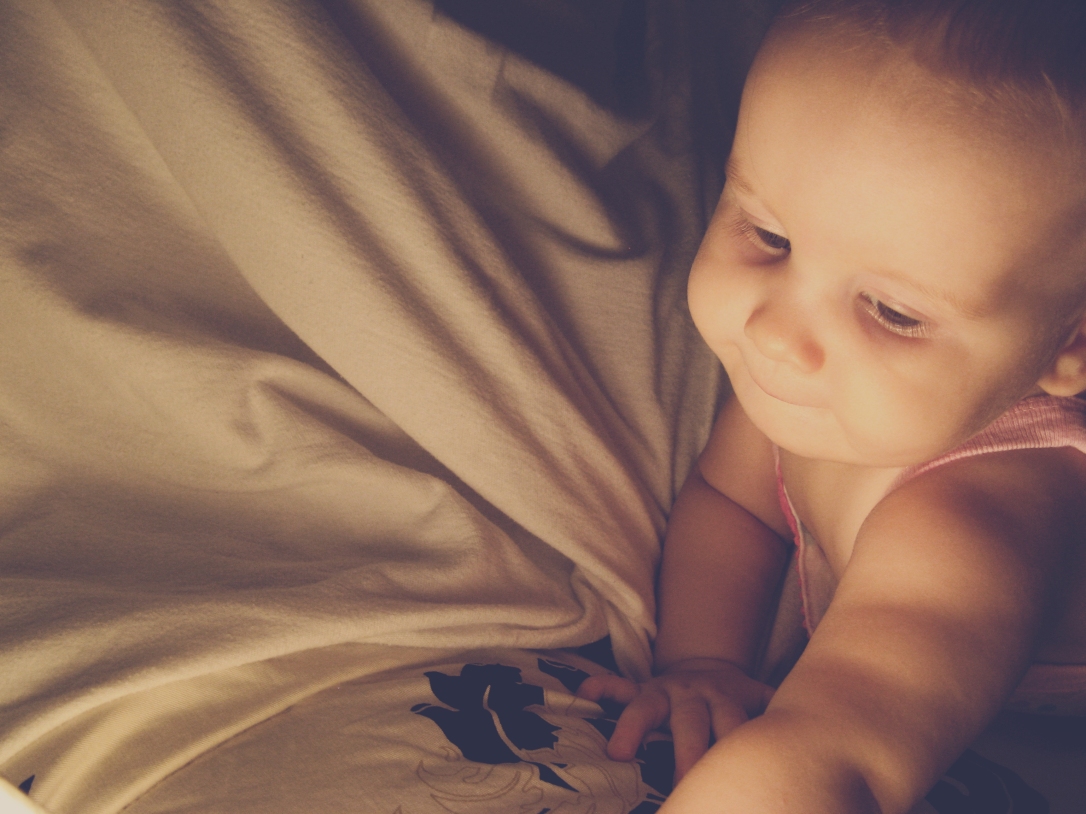 Aveline crawling on bed in evening light