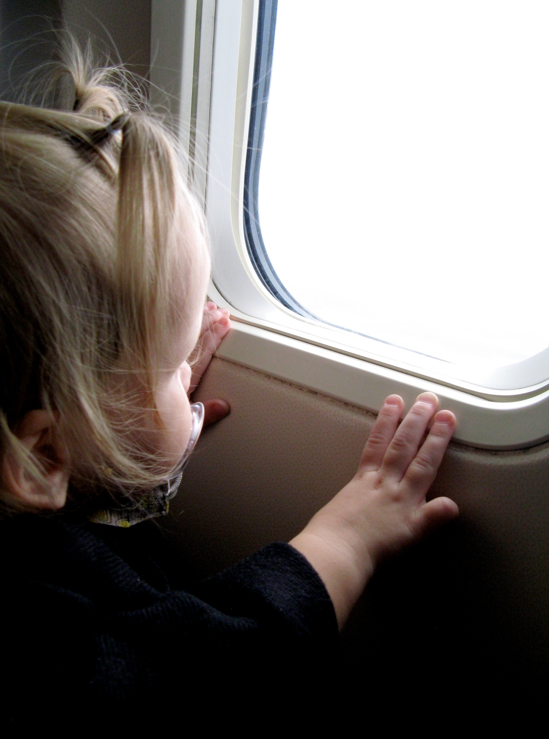 Toddler looking out airplane window - via the Oaxacaborn blog - photo by Gina Munsey