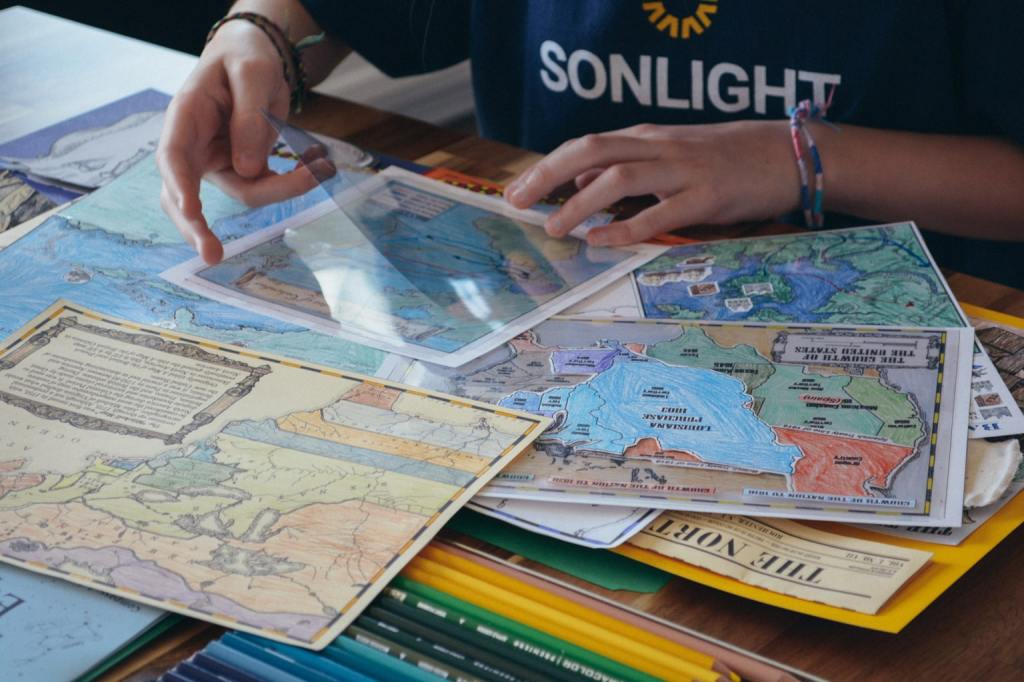 Mapping routes on overlays in the Sonlight history lapbook during homeschool history 
